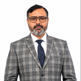 Professional portrait of a man with glasses in a gray plaid suit, white shirt, and navy tie, against a white background.