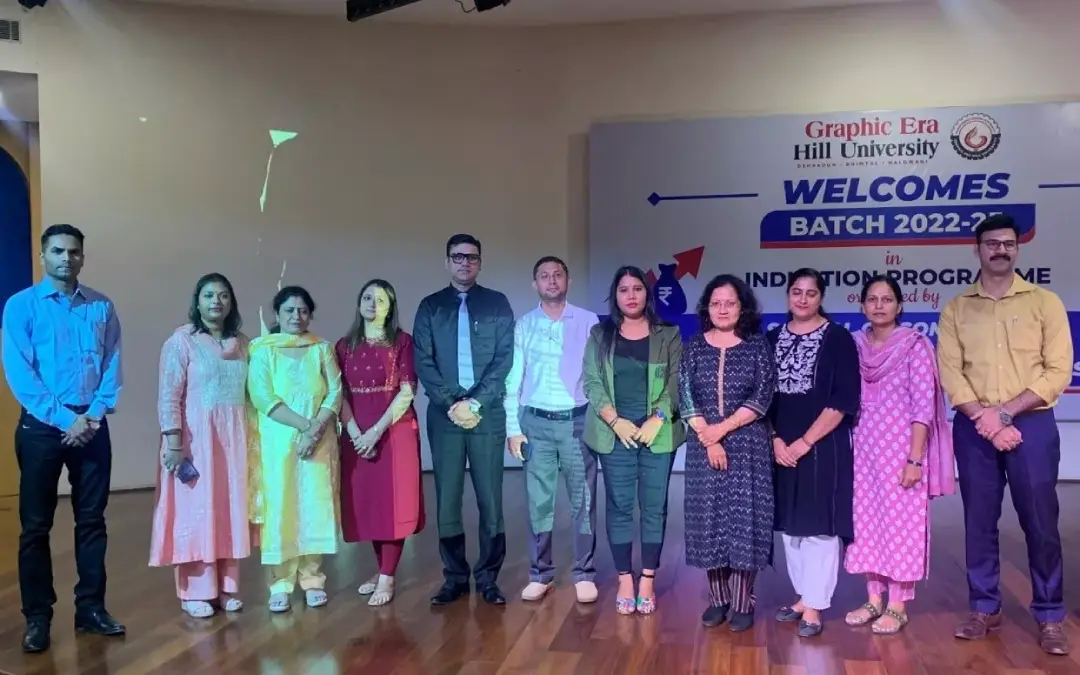 Group of students and staff pose on stage during Graphic Era Hill University welcome event for Batch 2022-23.