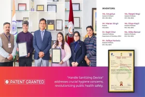 Group of six people posing with certificates in a lab/office, awards on shelves behind them, Indian flag visible on left.