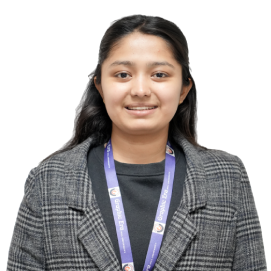 Portrait of a young woman wearing a gray plaid blazer and a purple lanyard, smiling at the camera against a white background.