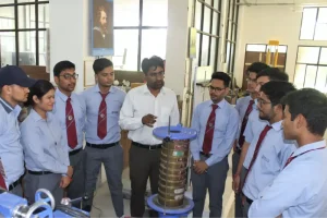 Instructor explains a coil device to a group of students in a lab setting.