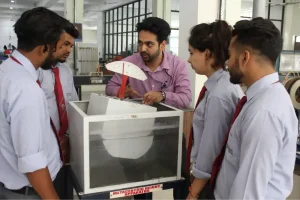 Instructor demonstrates a metacentric height apparatus to a group of students in a engineering lab.