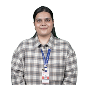 Woman with dark hair wearing a plaid shirt, blue lanyard, and ID badge, facing the camera.