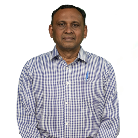 Portrait of a man in a blue and white checkered shirt standing against a white background, facing the camera.